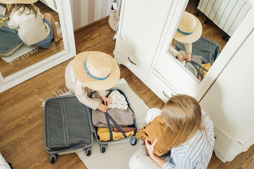 A woman and her daughter packing for a vacation.